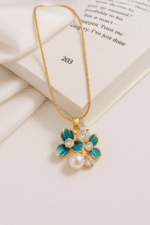 Elira Bloom Pendant in gold with three enamel blue petals, sparkling diamond accents, and a central pearl. Anti tarnish, elegant floral necklace for daily wear.